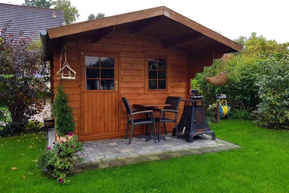 Gartenhaus aus Holz mit Gartenmöbeln